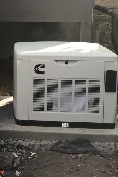 Small standby generator installed outdoors on a concrete pad.