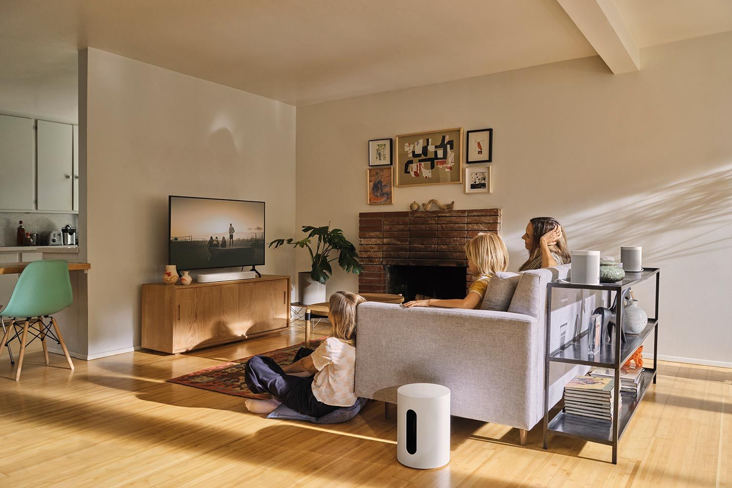 Modern living room with a wall-mounted TV displaying a family watching a movie.