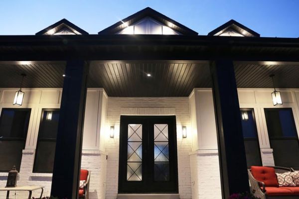 The front entrance of a house with a covered porch, illuminated by warm exterior lighting.