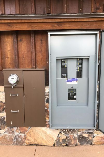 Electrical meter and breaker panel mounted on the exterior of a building.