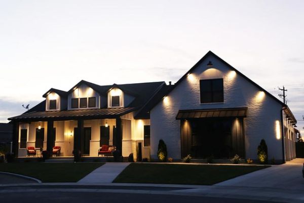 A house exterior at dusk, with strategically placed lights highlighting the architectural features.